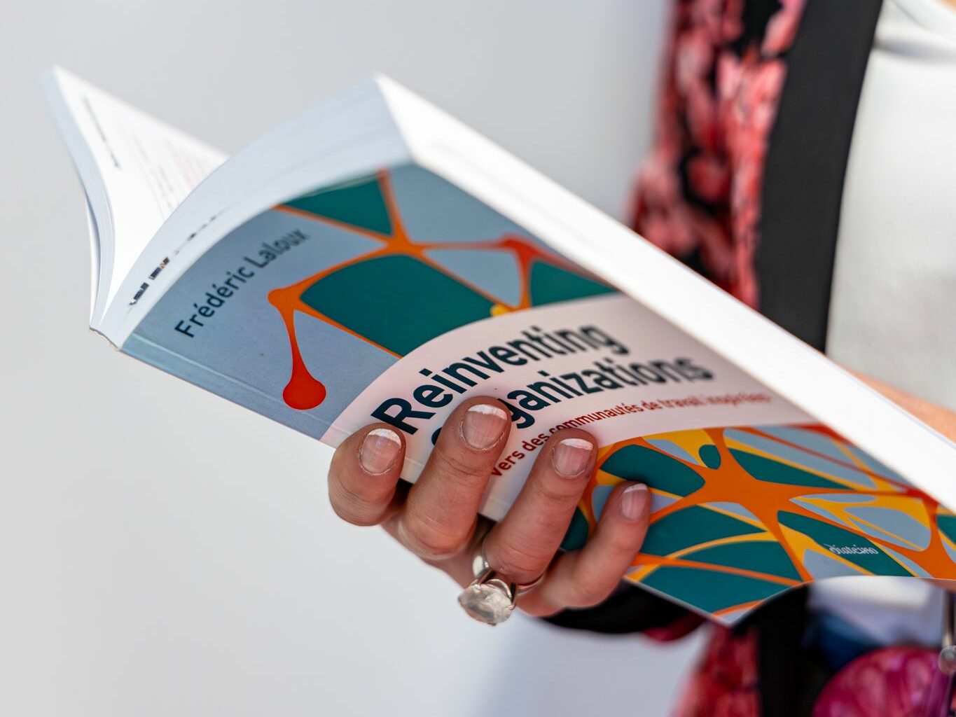 Donatella Consulting tient un livre sur les communautés de travail dynamiques. Elle s'en sert comme support pour présenter sa stratégie RH à une équipe professionnelle.